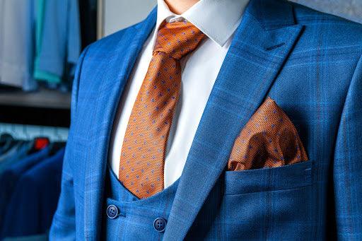 A blue suit with brown tie.